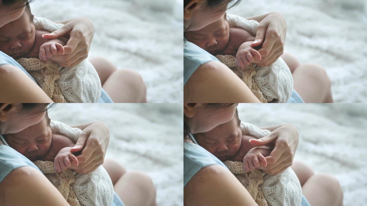 母亲牵手亚洲女性新生婴儿和阳光在早晨。可爱的小女孩三周大。医疗保健，爱情，关系概念。慢动作