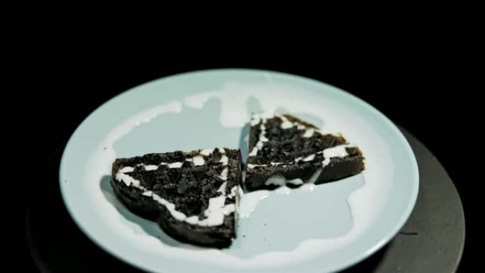 盘子上的深色心形华夫饼在黑色背景上打开。