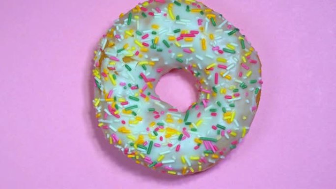 彩色背景上旋转的美味甜甜甜圈