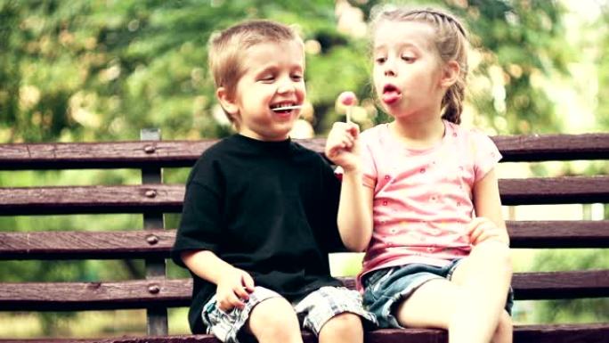 两个小孩在户外公园的长凳上玩得开心-股票视频