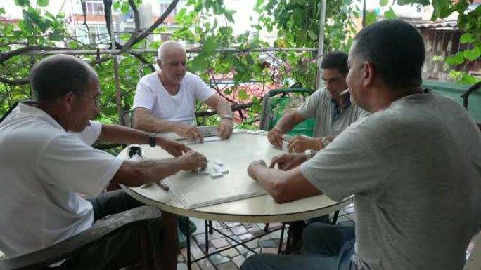 四名老年人成熟的古巴男子玩多米诺户外露台哈瓦那