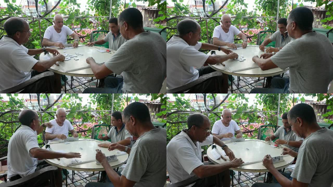 四名老年人成熟的古巴男子玩多米诺户外露台哈瓦那
