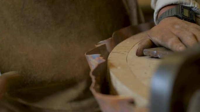 一名员工用金属锤击打铜以使其成形的特写镜头