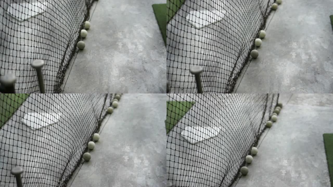 棒球练习场用棒球棒和球从网后射击