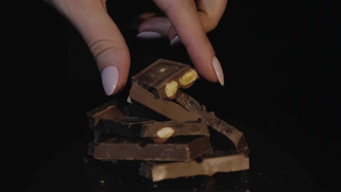 两个女人的手指拿走一块巧克力棒。慢动作