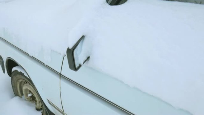 汽车被雪覆盖，在严冬风暴下。雪下院子里的汽车。