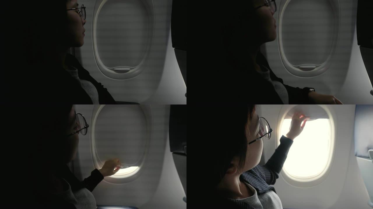 旅游亚洲妇女打开飞机窗户灯进入机舱旅行概念