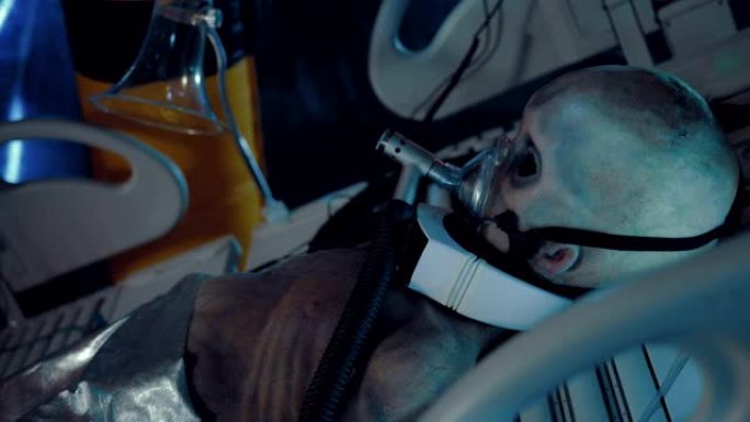 外星人躺在人工呼吸器下的手术台上。空间站操作单元。