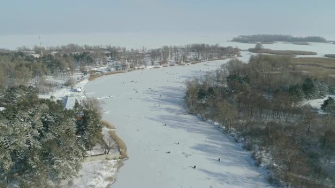 河的鸟瞰图，冰上的渔民。阳光明媚的冬日。乌克兰能源公司。4k视频
