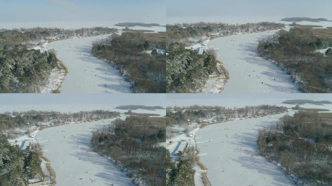 河的鸟瞰图，冰上的渔民。阳光明媚的冬日。乌克兰能源公司。4k视频