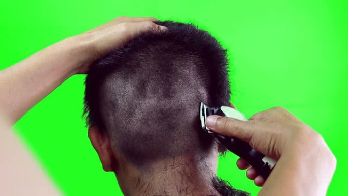 一个男孩用剪子理发，绿屏