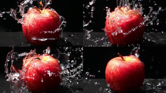 将淡水倒在黑色背景上的红苹果上