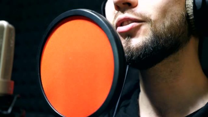无法识别的耳机男歌手在sound studio演唱歌曲。年轻人在情感上录制新的旋律或歌曲。创意音乐家