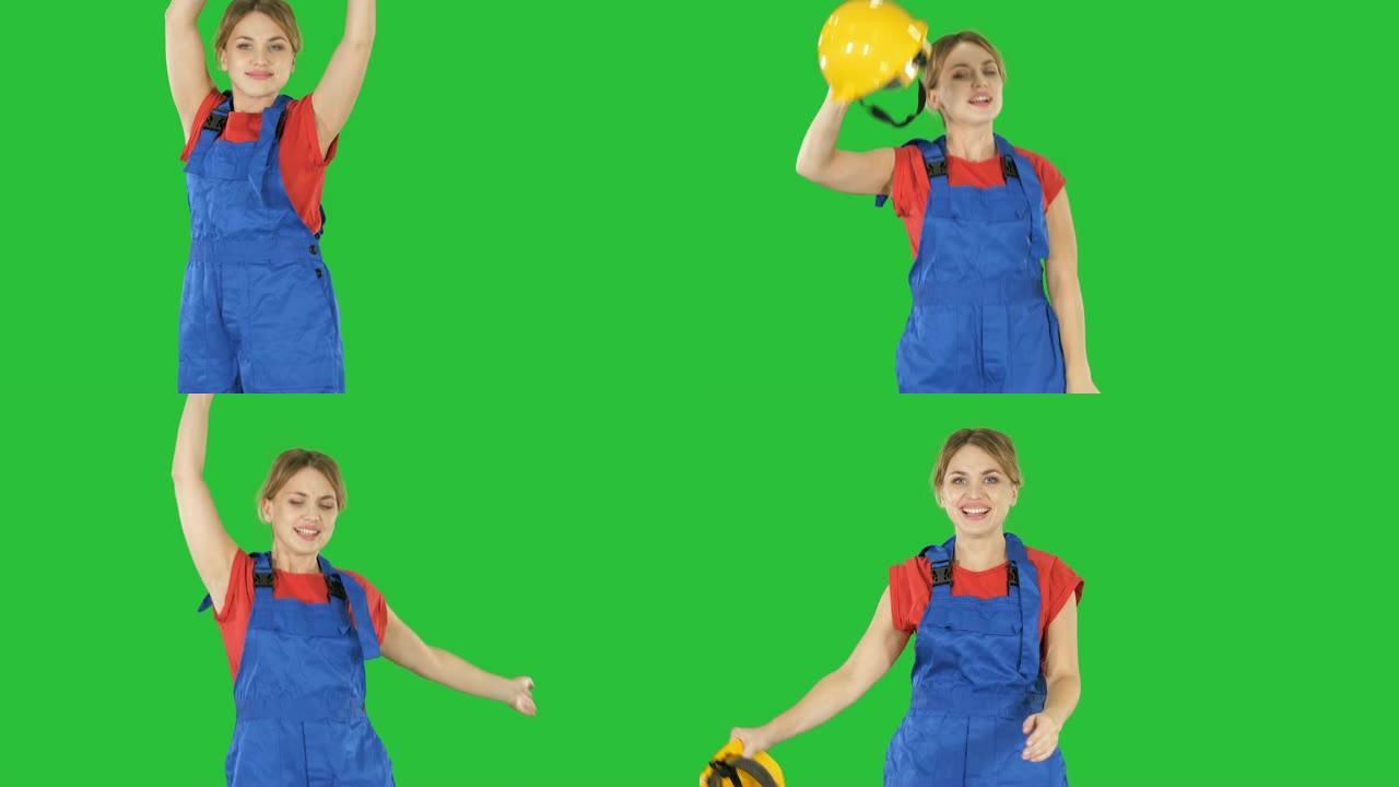 女建筑工人在绿屏上戴着安全帽跳舞，色键
