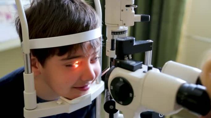 医生检查可爱的孩子的视力，眼科医生办公室裂隙灯的眼睛检查