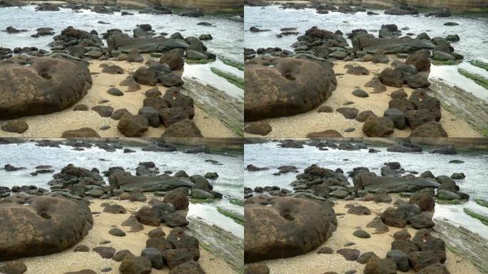 4k缓慢放大拍摄的海浪从海滩撞向岩石海岸。海浪溅到石头上，溪流猛烈流过许多岩石。
