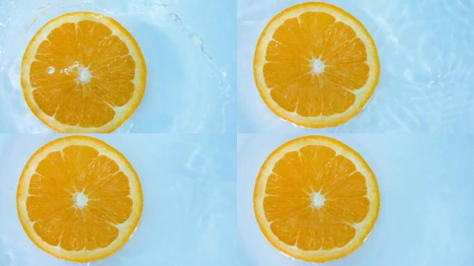 一块新鲜的切成薄片的橙子掉入水中，慢动作拍摄