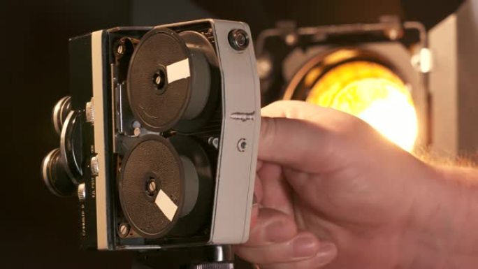 男子使用老式8毫米电影电影相机与发条机械电机