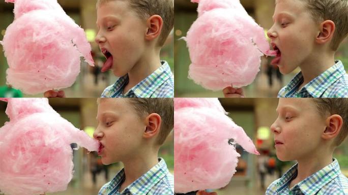一个男孩吃粉红色棉花糖的慢动作视频