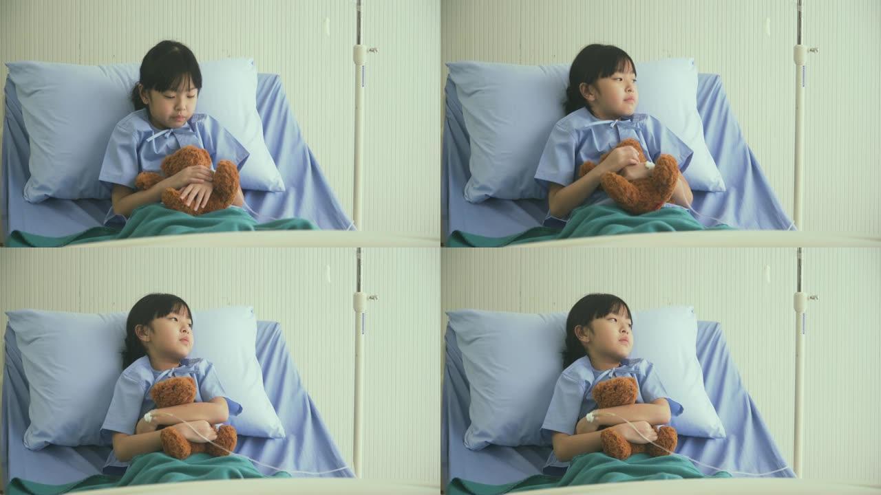前视图: 泰国女孩在医院病房里带着熊娃娃孤独