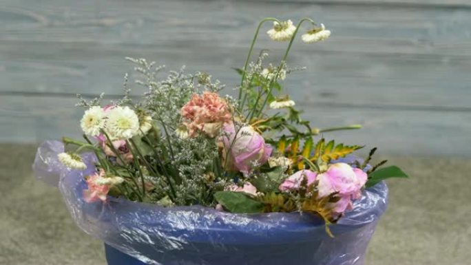 一束枯萎的鲜花被扔进垃圾桶