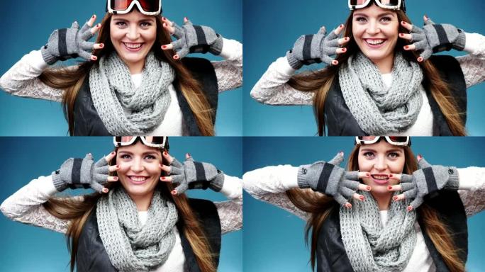 穿着暖和衣服的微笑滑雪女孩滑雪护目镜
