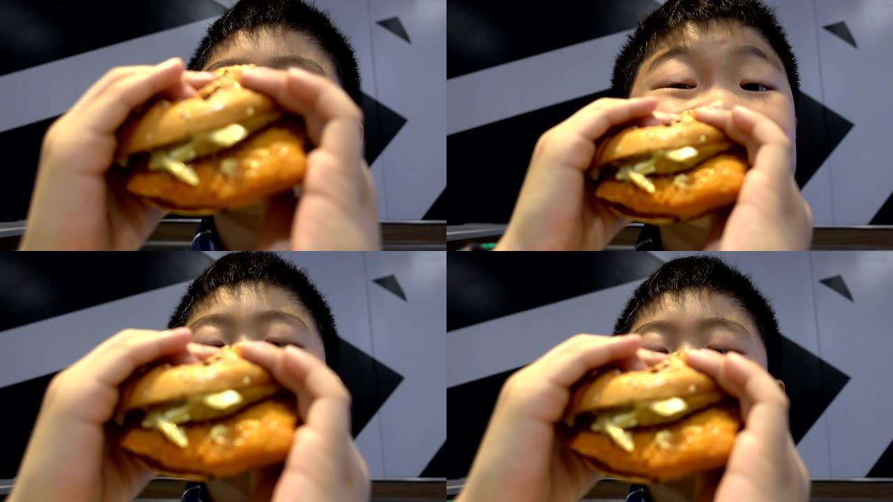 男孩在室内吃汉堡
