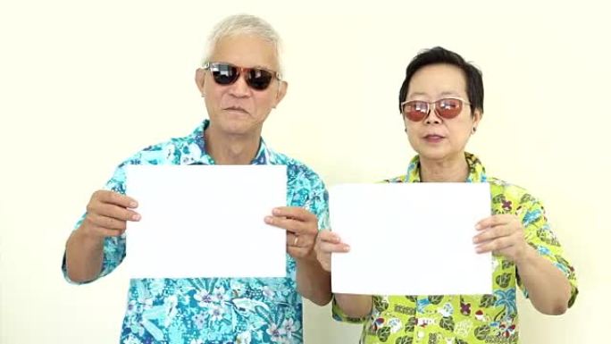 视频快乐亚洲老年夫妇拿着白色空白标志准备假日旅行