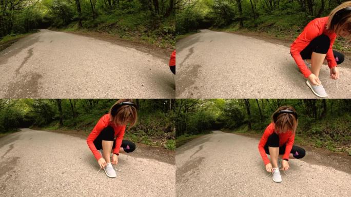 一个年轻的高加索女孩坐着绑住鞋带，然后在高加索的森林道路上慢跑。广角