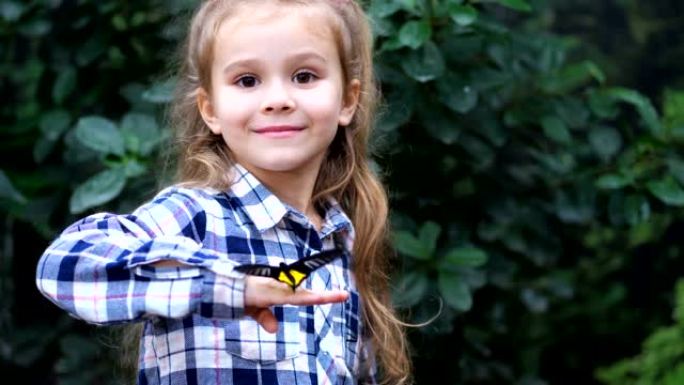 一个非常可爱的女孩手里拿着一只蝴蝶，转身装帧微笑。4k慢速移动