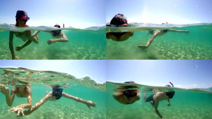 带着浮潜面具的夫妇在暑假在绿松石清水潜水时玩得开心，gopro圆顶拍摄