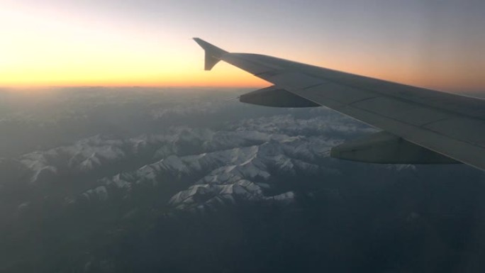 黄昏时在喜马拉雅山脉上飞行的机翼飞机的视图
