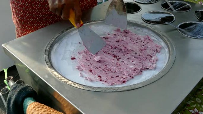 厨师正在用冷冻的平底锅在平底锅上做冰淇淋