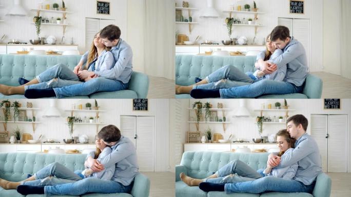 男人拥抱坐在沙发上并在厨房接吻的女士