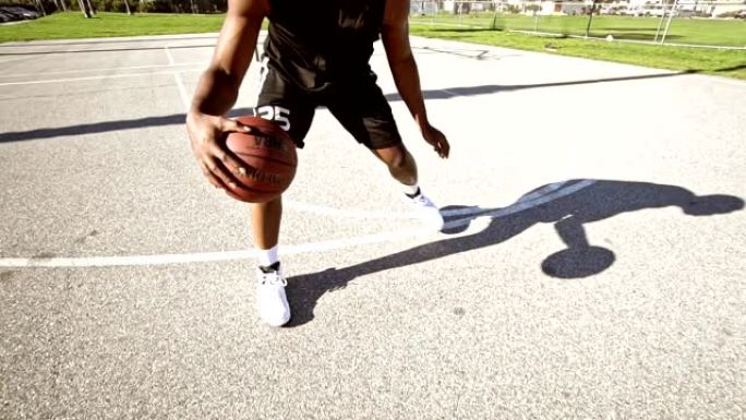 男子在街头篮球场弹跳球