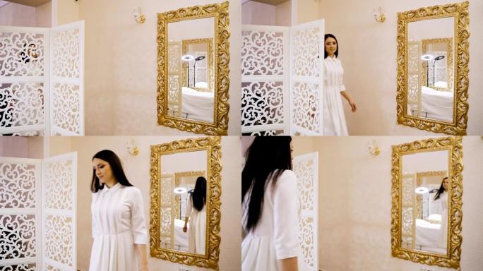 一个穿着白色连衣裙的女人来到房间，坐在镜子对面的沙发上，等待美容中心开始手术。