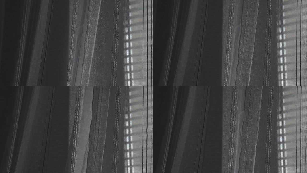 清晨，窗户上有百叶窗的透明灰色窗帘，被风轻轻移动
