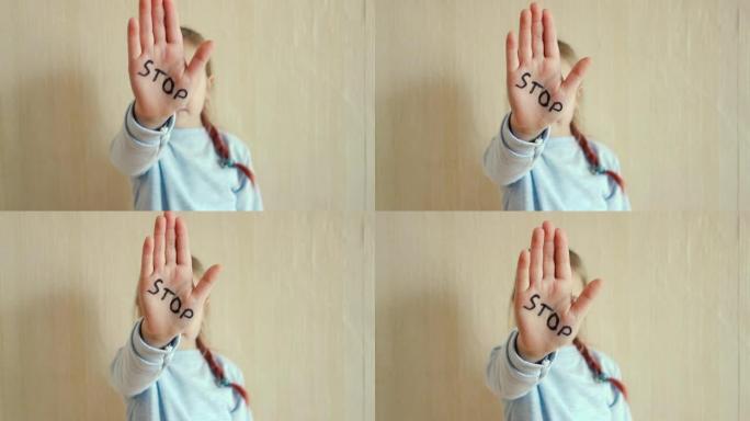 家庭暴力和虐待儿童的概念。一个小女孩展示她的手，上面写着停止这个词。儿童暴力。
