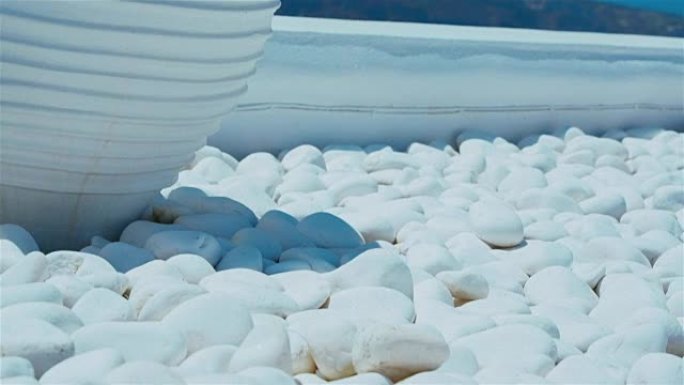 在蓝天背景下，传统的基克拉迪骨灰盒和白色鹅卵石的特写镜头