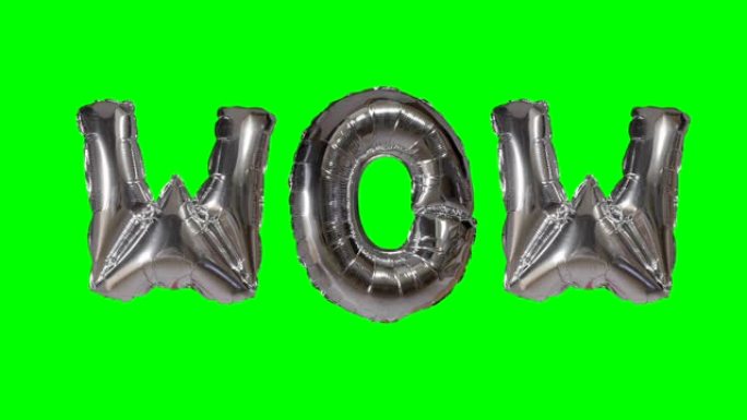 来自漂浮在绿色屏幕上的氦气银气球字母的wow单词