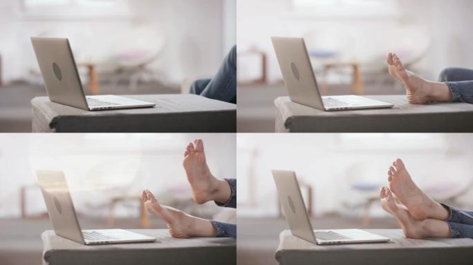 室内笔记本电脑前女性脚的特写