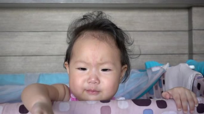 亚洲女婴在婴儿床上哭泣。慢动作