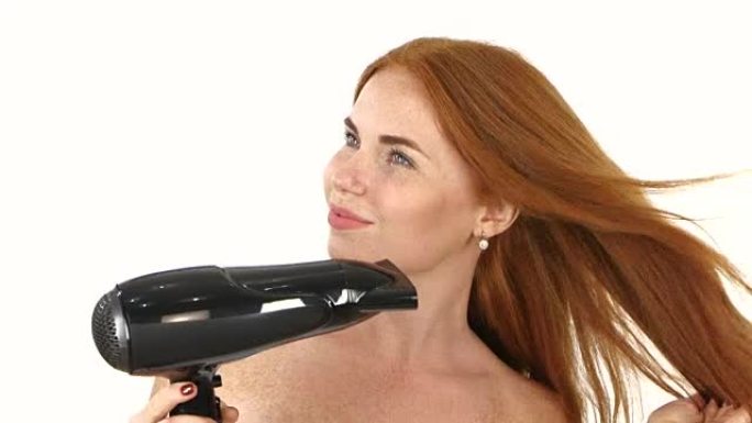 浴室里的红发女人用吹风机吹干头发。特写，浴室