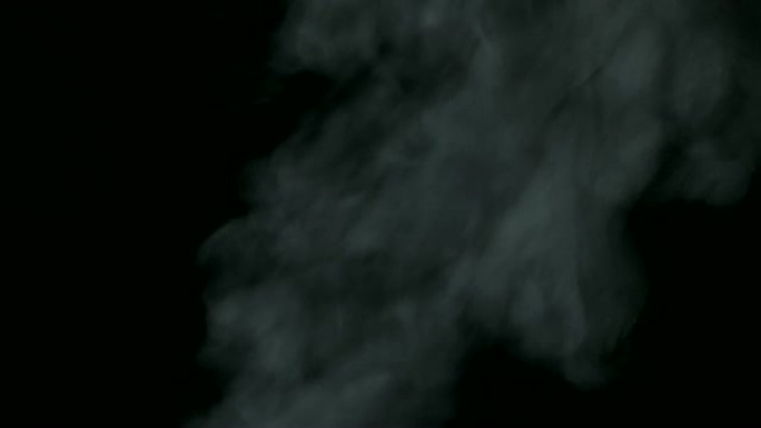 黑色背景上的烟雾云从底部到顶部从右侧慢慢吹来。白色蒸汽在黑色背景上轻盈，优美的扭曲。白烟效应。