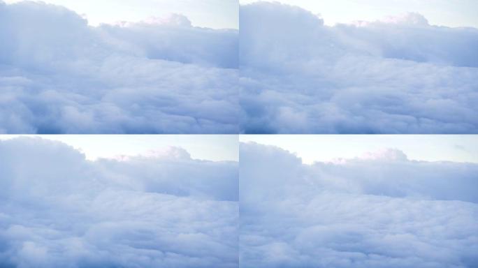 天空中飞行时，飞机窗外白色多云的天堂景观。从飞行飞机的窗户看天空中的白云。云景概念