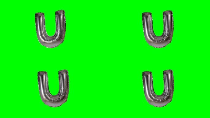 漂浮在绿色屏幕上的字母氦银气球中的大字母U