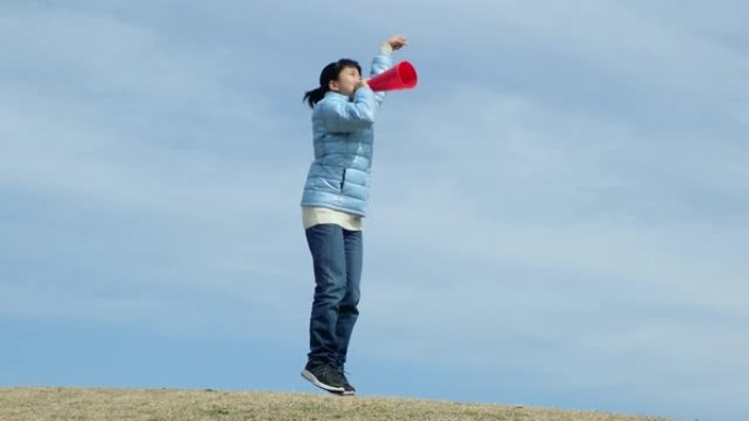 蓝天下用扩音器欢呼的日本女孩