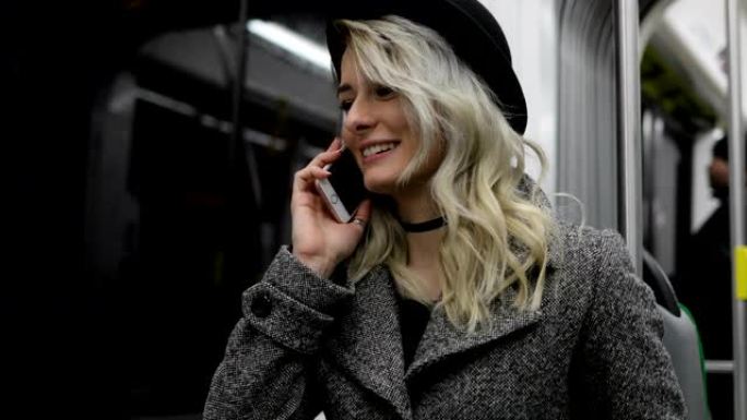 有人打电话来。戴着黑帽子的年轻女孩在公共交通工具上接听电话