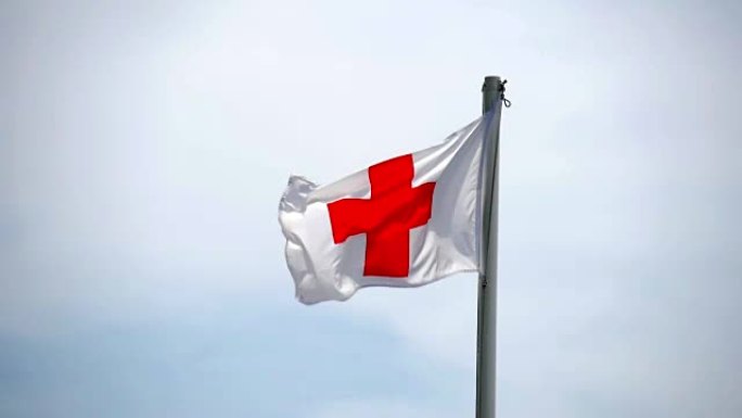 英国圣乔治国旗在旗杆上交叉，在微风中轻轻地吹着湛蓝的天空。
