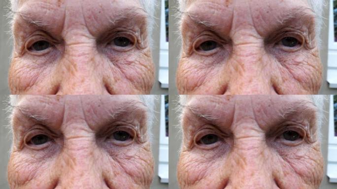 闭上老年妇女的灰色眼睛，周围有皱纹。祖母带着悲伤的景象看着镜头的肖像。高级女士的悲伤表情。